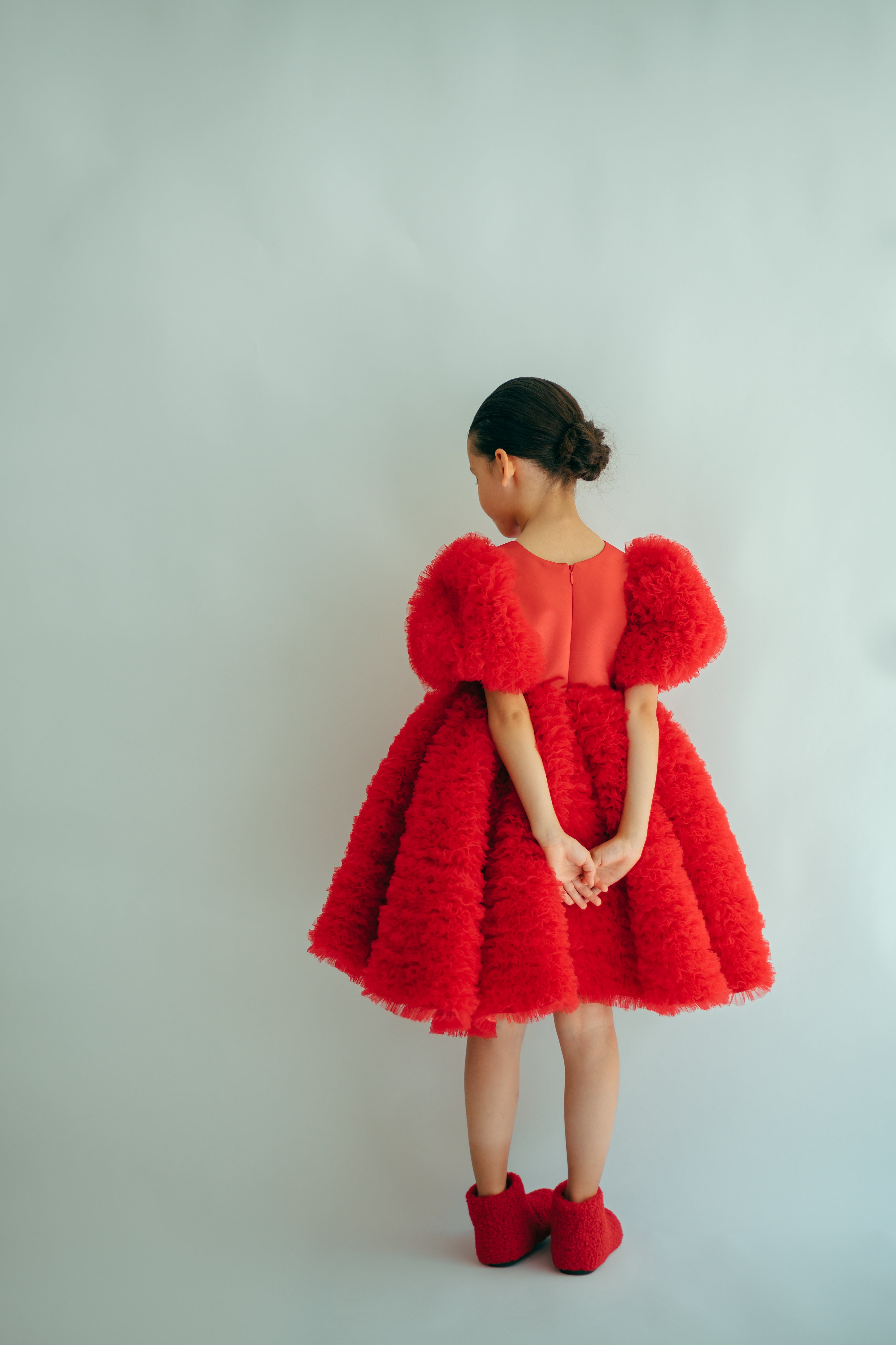 Girl wearing a red puffy and frilly dress